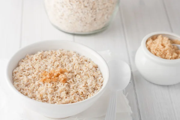 Un tazón de avena cocida con azúcar morena — Foto de Stock