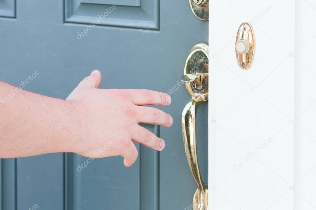 man's hand about to open front door