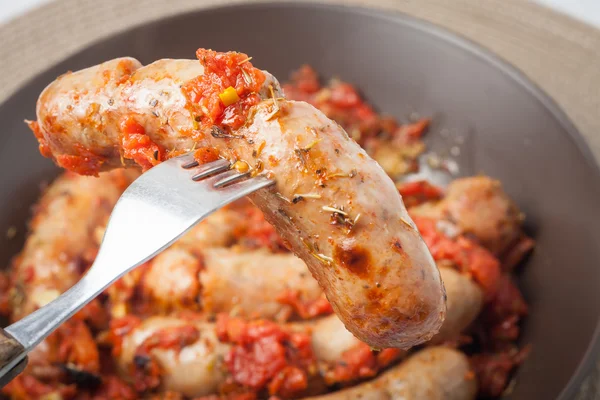 Oven cooked sausages with tomatos, garlic and italian herbs — Stock Photo, Image