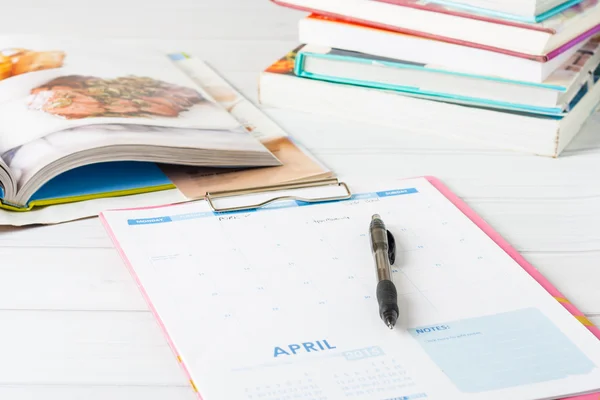 A calendar and stack of cookbooks — Stock Photo, Image