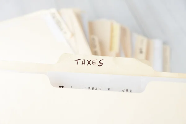 Folder de hârtie galbenă etichetat TAXES — Fotografie, imagine de stoc