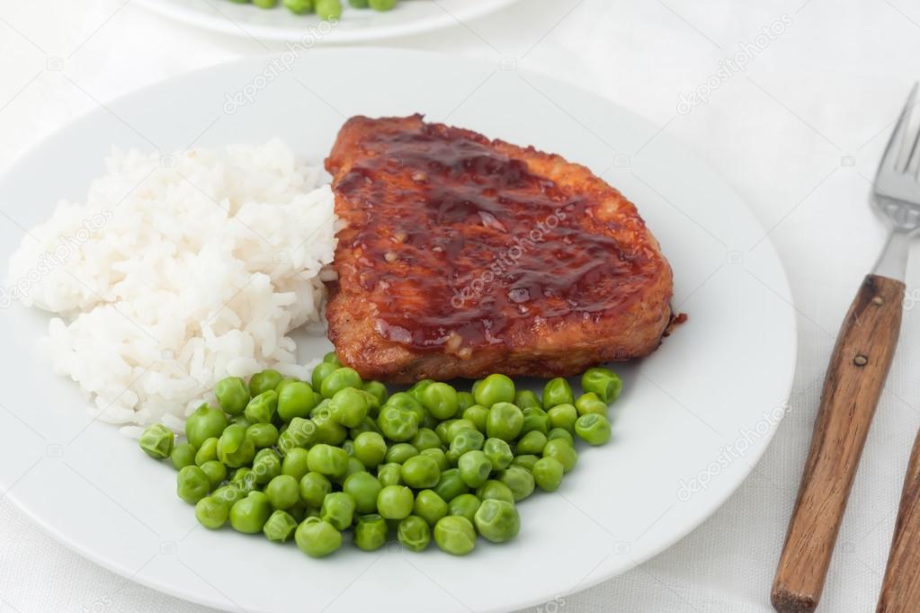 juicy cooked steaks with green peas