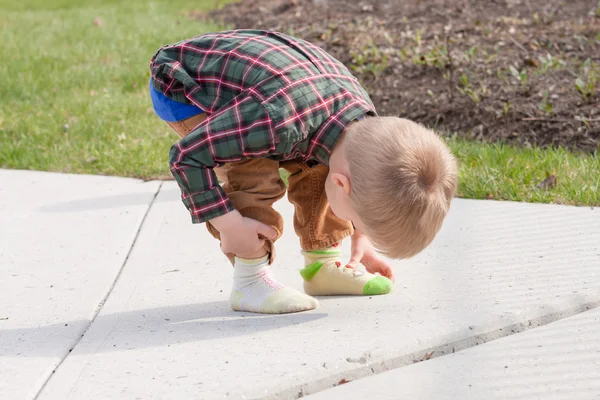 Verwirrtes Kleinkind blickt auf seine zwei verschiedenen Socken — Stockfoto