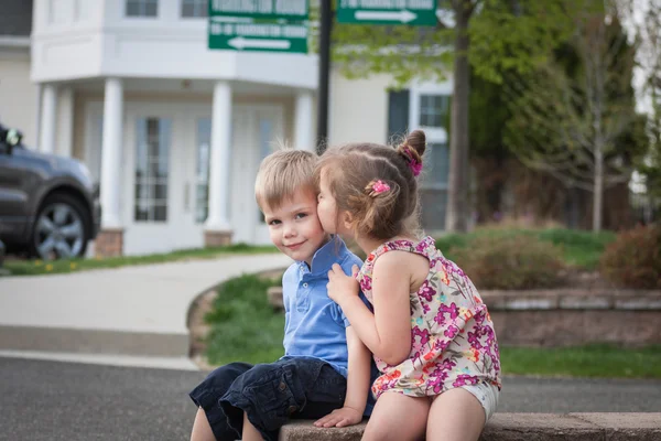 Little girl whispering something to her brothers ear — Stock Photo, Image