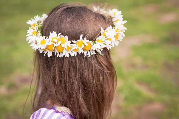 Guirnalda hecha con flores de manzanilla en una cabeza de niña — Foto de Stock