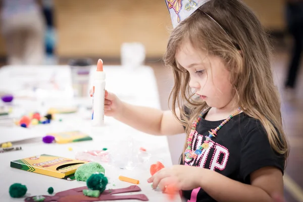 Little girl making handcraft at a table — Stock Photo, Image