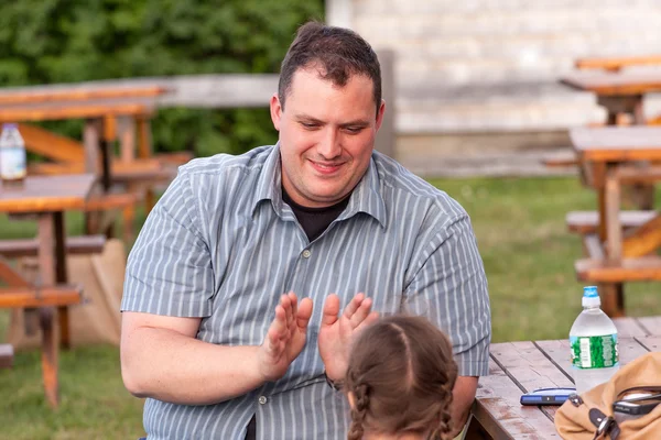 father playing clapping game with his daughter