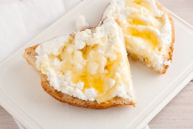 Peynirli ekmek ve doğrama kurulu beyaz bal