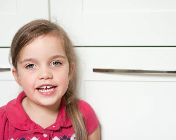 Portrait of a litle caucasian girl sitting in the kitchen and talking to her mother — Stock Photo, Image