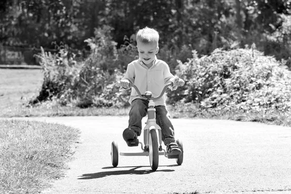 Imagem preto e branco de um menino de criança montando uma bicicleta — Fotografia de Stock