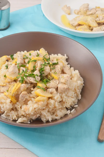 Riz cuit dans un bouillon de poulet et mélanger avec de la poitrine de poulet, zuchnini, ail et épices garni de persil — Photo