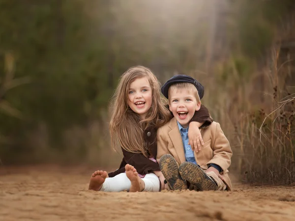 Retrato de hermanos sentados juntos y riendo — Foto de Stock