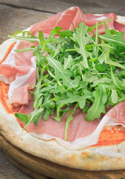 Italiensk pizza med skinka och färsk ruccola — Stockfoto