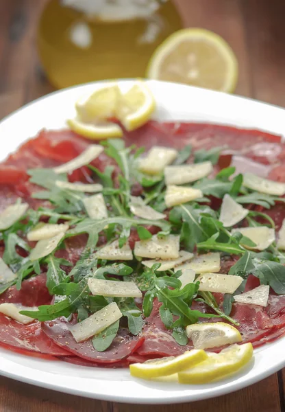 Bresaola com salada de rúcula e azeite — Fotografia de Stock