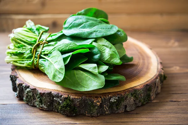 Spinach leaves on wooden circle