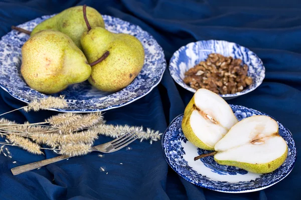 Вкусные Уильямс груши, дыня и грецкие орехи на голубом — стоковое фото