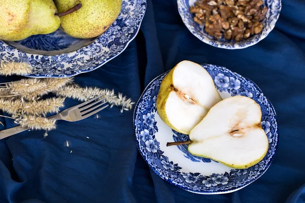 Вкусные Уильямс груши, дыня и грецкие орехи на голубом — стоковое фото