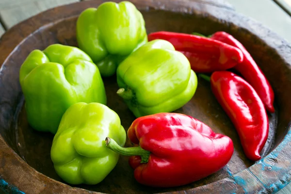 Diferentes pimientos dulces en plato de madera — Foto de Stock