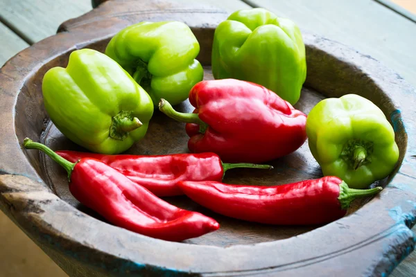 Diferentes pimientos dulces en plato de madera —  Fotos de Stock