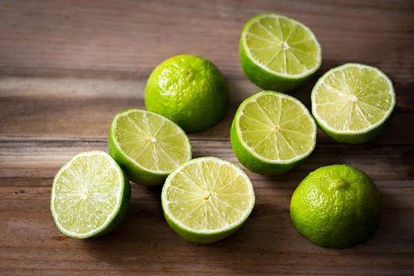 Fresh cut limes on wooden background — Stock Photo, Image