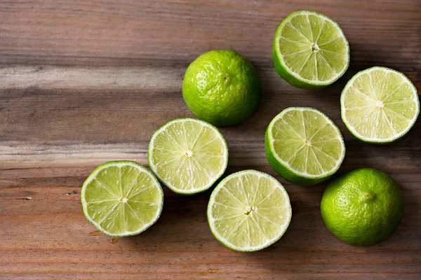 Fresh cut limes on wooden background — Stock Photo, Image