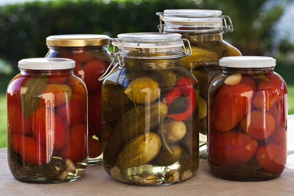自家製缶詰のトマトとキュウリの屋外キッチンにガラスの瓶 — ストック写真