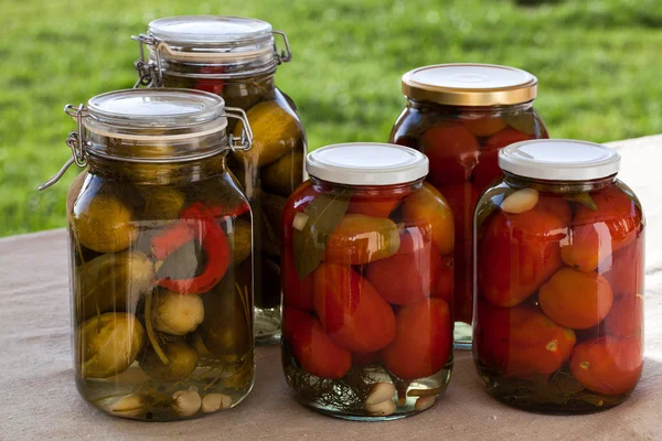 自家製缶詰のトマトとキュウリの屋外キッチンにガラスの瓶 — ストック写真