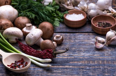 Mantar, maydanoz, dereotu, soğan, zeytinyağı, baharat - ahşap arka plan üzerinde mantar yemekleri hazırlanması için malzemeler