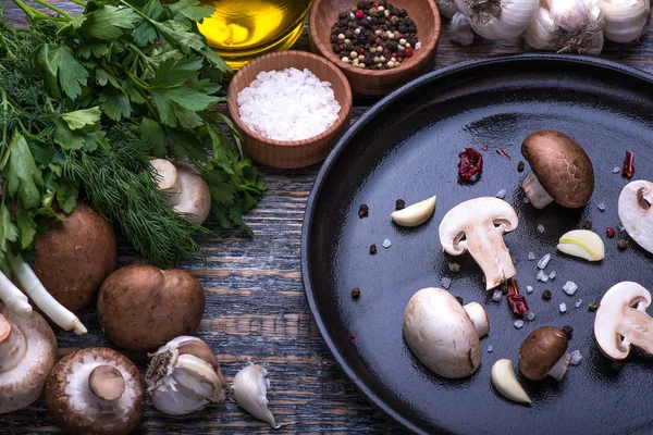 Cogumelos, salsa, endro, cebola, azeite, especiarias - ingredientes para a preparação de pratos de cogumelos no fundo de madeira — Fotografia de Stock