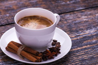 Kahve fincanı ve fasulye, bisküvi ahşap bir masa üzerinde. Koyu arka plan.