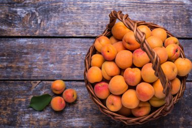 Güzel kokulu ve olgun kayısı ahşap arka plan üzerinde bir sepet içinde. seçici odak