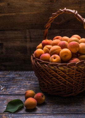 Güzel kokulu ve olgun kayısı ahşap arka plan üzerinde bir sepet içinde. seçici odak