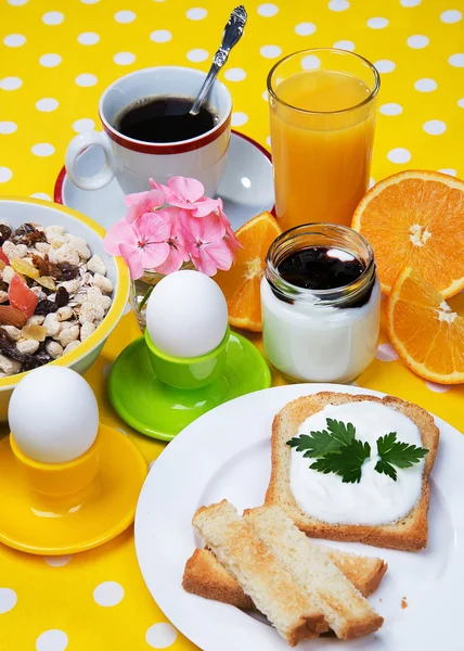 Breakfast including coffee, toast, eggs,  orange juice, muesli, yogurt,  fruits — Stock Photo, Image