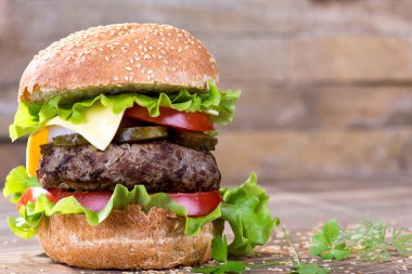 Büyük hamburger biftek pirzola ve sebze ahşap plaka üzerinde