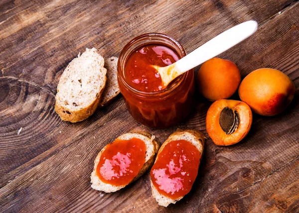 Toast with apricot jam on a wooden background — Stock Photo, Image