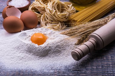 Ahşap arka plan üzerinde makarna yemek pişirmek için malzemeler