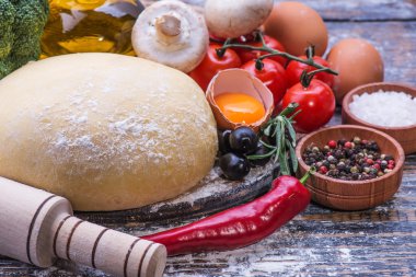 Ahşap arka plan üzerinde pizza yemek pişirmek için maddeler kümesi