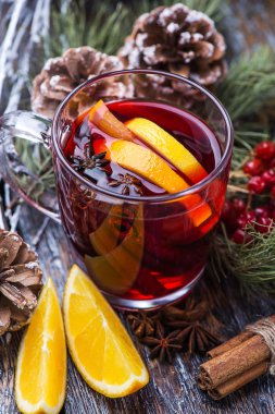 Sıcak içecek sıcak kırmızı şarap cam ahşap arka plan üzerinde bir fincan. Evlendirmek Noel