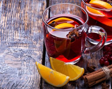 Sıcak bir içecek, mulled şarap, kırmızı cam ahşap arka plan üzerinde bir fincan
