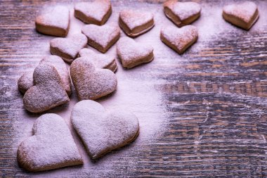 Bisküvi ve kurabiyeler ahşap masa, arka plan üzerinde kalp şeklinde. St.Valentine