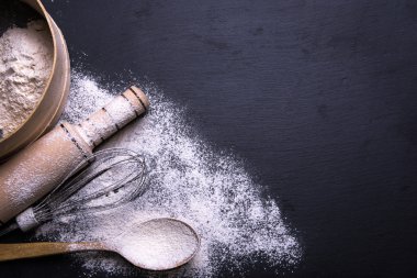 Malzemeler kurabiye, bisküvi, un üzerinde pişirme için siyah arka plan.