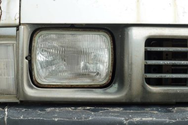 Eski bir arabanın sol ön spot ışığının ön görüntüsü..