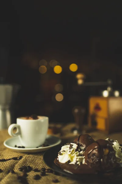 Bir fincan kahve ve çöl, kapuçino. Kahve öğütücüsüyle, espresso makinesiyle ve çikolatayla güzel bir kompozisyon. Restoran ve kahve dükkanı. Güzel kremalı bokeh..