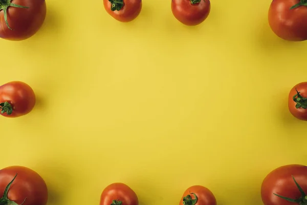 Sarı arka planda kırmızı domateslerden yapılmış bir çerçeve. Ücretsiz renk biçimi.