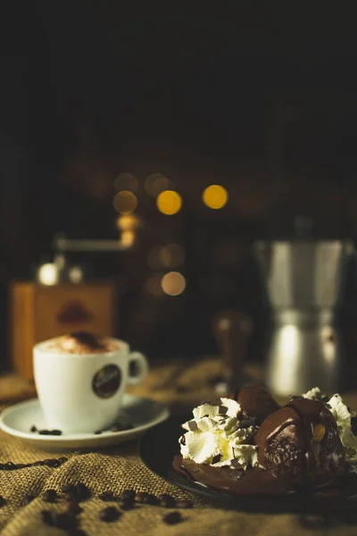 Bir fincan kahve ve çöl, kapuçino. Kahve öğütücüsüyle, espresso makinesiyle ve çikolatayla güzel bir kompozisyon. Restoran ve kahve dükkanı. Güzel kremalı bokeh..