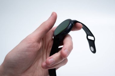 Erkek bileğine takılan yuvarlak ekran, hafif arka planda gevşek eller, stili ve teknolojiyi sembolize ediyor..