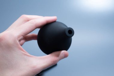 Uzun plastik başlıklı siyah tıbbi lavman ampulü ışık masasında dikiliyor..