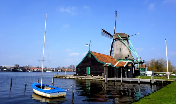 Vindmøller og elv og båt i holland – stockfoto