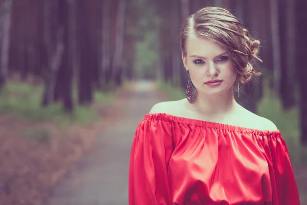 Portréja egy szép fiatal lány, egy piros ruha szabadban — Stock Fotó