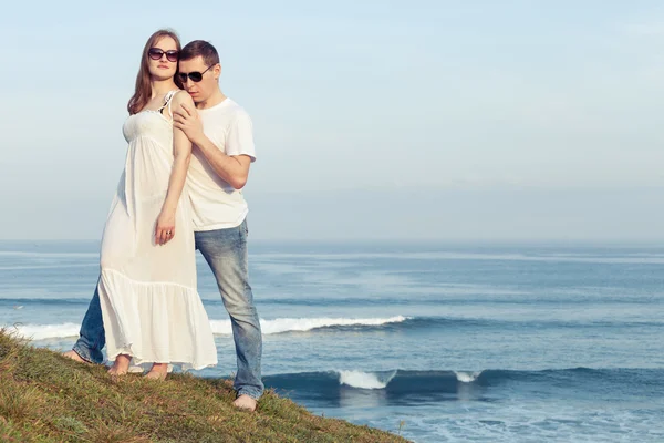 Älskande par stående på stranden på dagarna. — Stockfoto